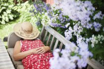 Frau liegt auf Bank im heimischen Garten — Stockfoto