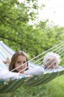 Girl and boy lying on striped hammock, selective focus — Stock Photo