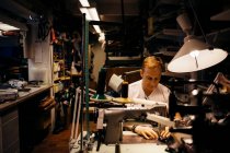 Reifer Mann mit blonden Haaren arbeitet in Lederwerkstatt — Stockfoto