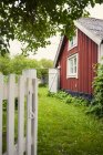 Garden by red wooden house, rural scene — Stock Photo