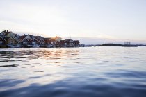 Houses and motorboats by sea at sunset, differential focus — Stock Photo