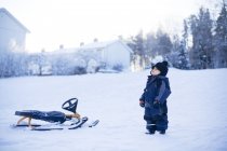 Seitenansicht eines kleinen Jungen, der auf Schnee steht — Stockfoto