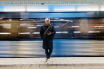 Man texting at train station — Stock Photo