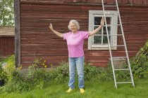 Portrait of senior woman in front of cottage — Stock Photo