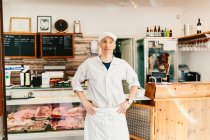 Portrait of butcher standing and looking at camera in store — Stock Photo