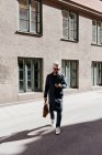 Homem andando pela rua com telefone inteligente em Estocolmo, Suécia — Fotografia de Stock