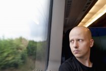 Man looking through window on train — Stock Photo
