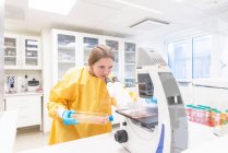 Mujer en la cubierta de laboratorio que trabaja en laboratorio - foto de stock
