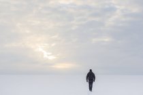 Vista posteriore dell'uomo maturo che cammina sulla neve — Foto stock