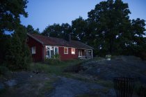 Дом с красным освещением в сумерках, Швеция — стоковое фото