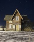 Casa por la noche durante el invierno, enfoque selectivo - foto de stock