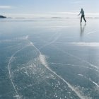 Mulher adulta média patinação no gelo no lago congelado — Fotografia de Stock