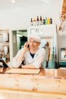 Butcher talking on phone at butcher shop — Stock Photo