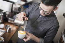 Barista haciendo café con leche, céntrate en el primer plano - foto de stock