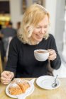 Une femme souriante dans un café en Angleterre — Photo de stock