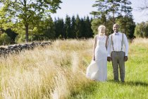 Couple nouvellement marié dans prairie — Photo de stock