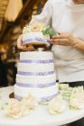 Cropped view of baker putting together cake — Stock Photo