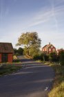 Maisons le long de la route rurale contre le ciel bleu — Photo de stock