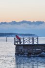 Teenager steht bei Sonnenuntergang auf Seebrücke — Stockfoto