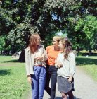 Tres mujeres jóvenes caminando por el parque - foto de stock