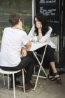 Jovem casal sentado no café calçada, foco seletivo — Fotografia de Stock