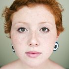 Porträt einer jungen Frau mit rotem Haar, die in die Kamera blickt — Stockfoto