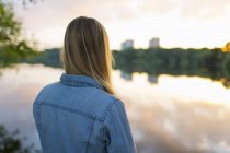 Девочка-подросток, стоящая на берегу озера — стоковое фото