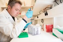 Homem em casaco branco trabalhando em laboratório — Fotografia de Stock