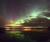 Aurora borealis and clouds reflecting in water — Stock Photo