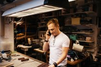 Mature man with blond hair working in leather workshop — Stock Photo