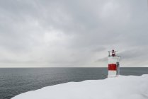 Faro en la costa nevada, norte de Europa - foto de stock