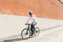 Hombre hablando por teléfono inteligente mientras se monta en bicicleta - foto de stock