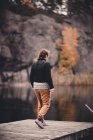 Вид сзади на женщину, идущую по озеру — стоковое фото