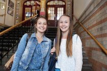 Portrait of two teenage girls in school building, selective focus — Stock Photo