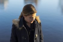 Porträt eines Teenager-Mädchens am Wasser, Fokus auf den Vordergrund — Stockfoto