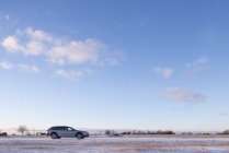 Вид автомобиля сбоку на заснеженном поле — стоковое фото
