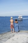 Вид сзади мальчика и девочки, смотрящих на лодку — стоковое фото