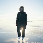 Metà donna adulta in pattini su ghiaccio in piedi sul lago ghiacciato — Foto stock