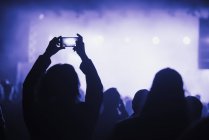 Woman using smart phone on concert — Stock Photo