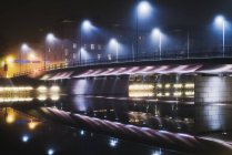 Illuminated bridge over river at night, northern europe — Stock Photo