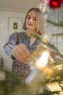 Junge Frau schmückt Weihnachtsbaum, selektiver Fokus — Stockfoto