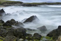 Vista panorámica de olas rompiendo sobre rocas - foto de stock
