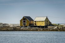 Maisons jaunes au bord de la rivière, Europe du Nord — Photo de stock