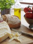 Сыр пармезан и хлеб на разделочной доске — стоковое фото