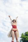Joven acróbata femenina con los brazos extendidos contra el cielo - foto de stock