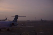 Aviones en el aeropuerto al atardecer, norte de Europa - foto de stock