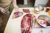 Boucher préparant la viande de gibier sur la table — Photo de stock