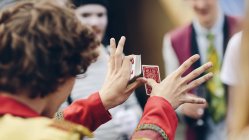 Young circus performer showing card trick — Stock Photo