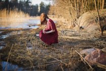 Jovem mulher agachada em zonas húmidas, foco seletivo — Fotografia de Stock