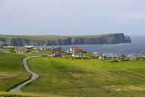Strada vuota e villaggio dal mare sullo sfondo — Foto stock